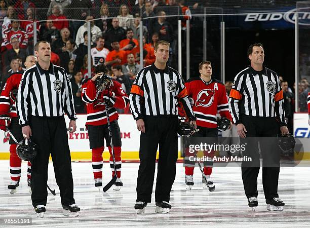Linesman David Brisebois referee Eric Furlatt and referee Mike Leggo stand for the national anthem prior to the start of the game between the...