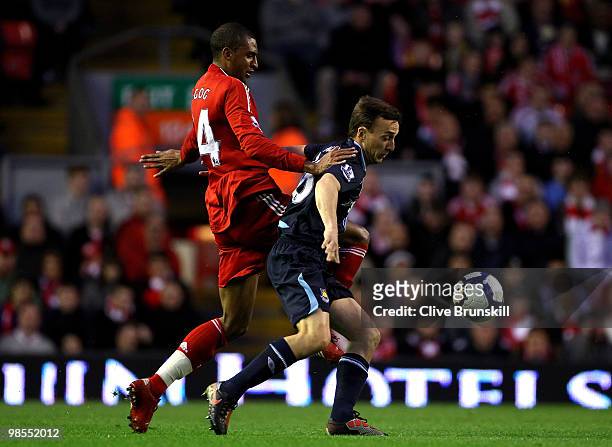 Mark Noble of West Ham United competes with David Ngog of Liverpool during the Barclays Premier League match between Liverpool and West ham United at...