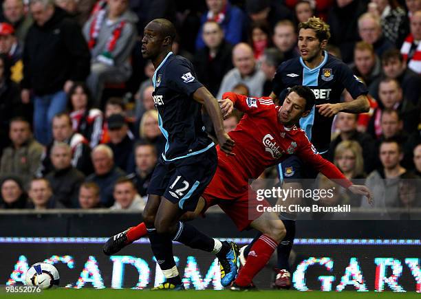 Carlton Cole of West Ham United is tackled by Maxi Rodriguez of Liverpool during the Barclays Premier League match between Liverpool and West Ham...