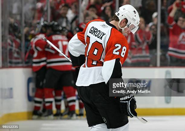 Claude Giroux of the Philadelphia Flyers looks away dejected as the New Jersey Devils celebrate a goal in Game Two of the Eastern Conference...