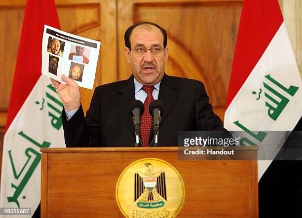 This handout image provided by the Iraqi Prime Minister office shows Iraq's Prime Minister Nouri al-Maliki holding photographs of a man identified by...