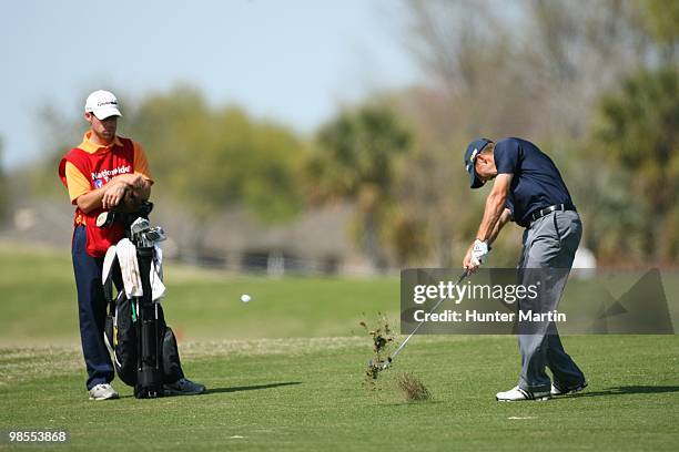 Patrick Grady hits a shot while his caddie looks on during the second round of the Chitimacha Louisiana Open at Le Triomphe Country Club on March 26,...