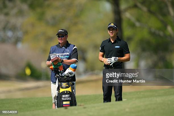 Manuel Villegas looks on with his caddie during the second round of the Chitimacha Louisiana Open at Le Triomphe Country Club on March 26, 2010 in...