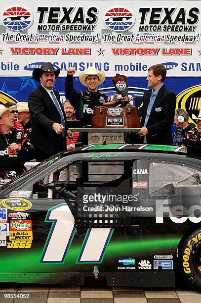 Denny Hamlin, driver of the of the FedEx Ground Toyota, celebrates with the trophy in victory lane after he won the NASCAR Sprint Cup Series Samsung...