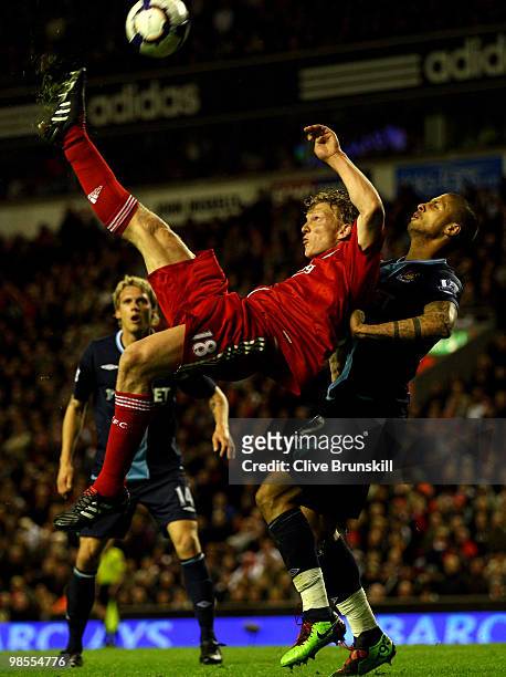 Dirk Kuyt of Liverpool performs a bicycle kick under pressure from Manuel Da Costa of West Ham United during the Barclays Premier League match...