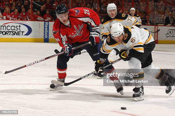 Alexander Semin of the Washington Capitals and Dennis Wideman of the Boston Bruins fight for a loose puck during a NHL hockey game on April 11, 2010...