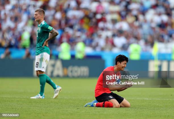 Son Heung-Min of Korea Republic sinks to his knees as he celebrates following his sides victory, as a dejected Toni Kroos of Germany can be seen...