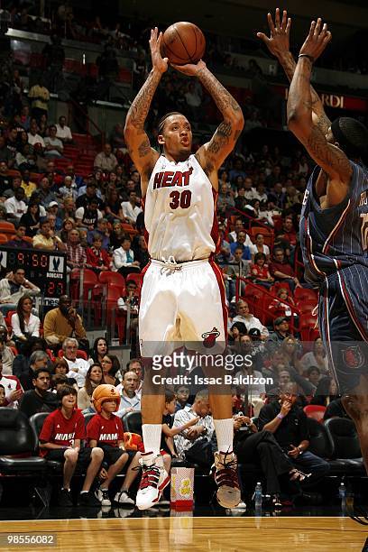 Michael Beasley of the Miami Heat shoots a jump shot against Tyrus Thomas of the Charlotte Bobcats during the game at American Airlines Arena on...