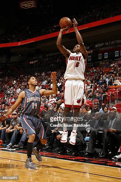 Mario Chalmers of the Miami Heat shoots a jump shot against D.J. Augustin of the Charlotte Bobcats during the game at American Airlines Arena on...