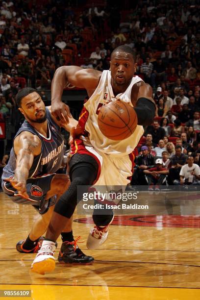 Dwyane Wade of the Miami Heat drives to the basket past D.J. Augustin of the Charlotte Bobcats during the game at American Airlines Arena on March...