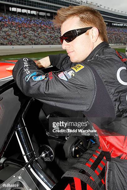 Jason Leffler, driver of the Great Clips Toyota, leans on his car prior to the start of the NASCAR Nationwide Series O'Reilly Auto Parts 300 at Texas...