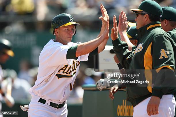 Mark Ellis of the Oakland Athletics is congratulated by the dugout during the game against the Seattle Mariners at the Oakland Coliseum in Oakland,...