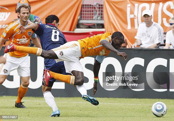 Dominic Oduro of the Houston Dynamo is tripped up by Mariano Trujillo of Chivas USA at Robertson Stadium on April 17, 2010 in Houston, Texas.