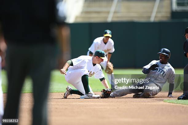 Cliff Pennington of the Oakland Athletics tags out Chone Figgins of the Seattle Mariners during the game against the Mariners at the Oakland Coliseum...