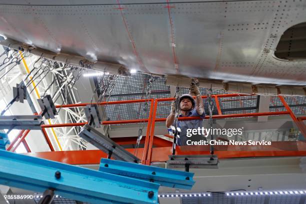 Technician adjusts China's first domestically made C919 passenger jet before its trial flight on June 25, 2018 in Shanghai, China. The C919 aircraft...