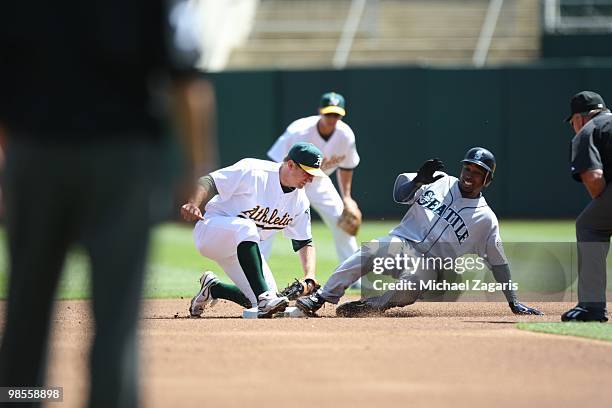 Cliff Pennington of the Oakland Athletics tags out Chone Figgins of the Seattle Mariners during the game against the Mariners at the Oakland Coliseum...