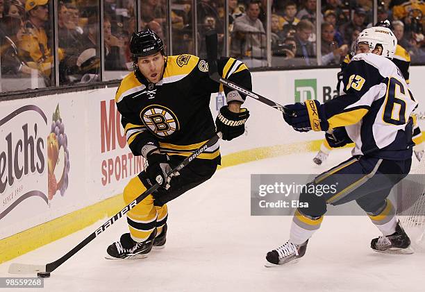 Dennis Wideman of the Boston Bruins tries to keep the puck from Tyler Ennis of the Buffalo Sabres in Game Three of the Eastern Conference...