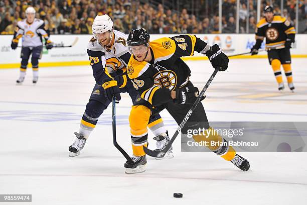 David Krejci of the Boston Bruins skates with the puck against Jason Pominville of the Buffalo Sabers in Game Three of the Eastern Conference...