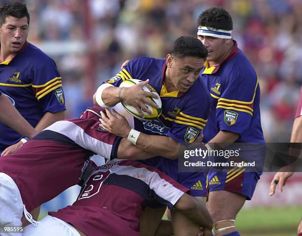 Eroni Clarke of the Highlanders is tackled by the Reds defence during the Super 12 rugby union match between Queensland Reds v Otago Highlanders at...