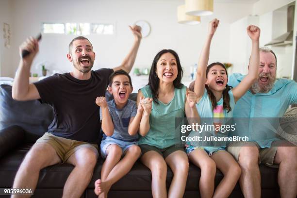 family cheering while watching sport at home - mom cheering stock pictures, royalty-free photos & images