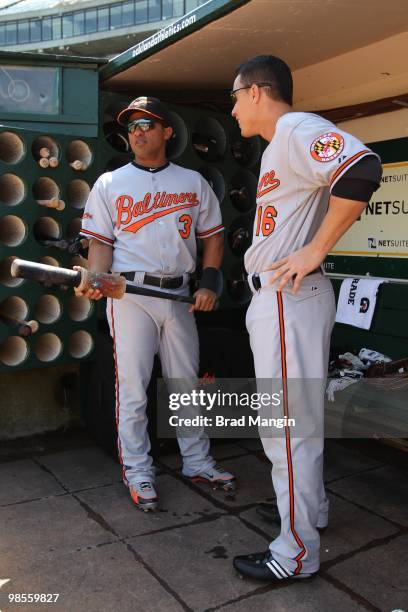 Cesar Izturis and Lou Montanez of the Baltimore Orioles get ready in the dugout before the game against the Oakland Athletics at the Oakland-Alameda...