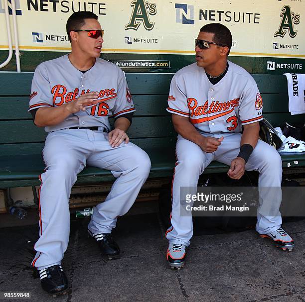 Cesar Izturis and Lou Montanez of the Baltimore Orioles talk in the dugout before the game against the Oakland Athletics at the Oakland-Alameda...