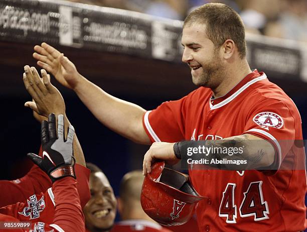 Mike Napoli of the Los Angeles Angels of Anaheim gets congratulated after a run against the Toronto Blue Jays during a MLB game at the Rogers Centre...