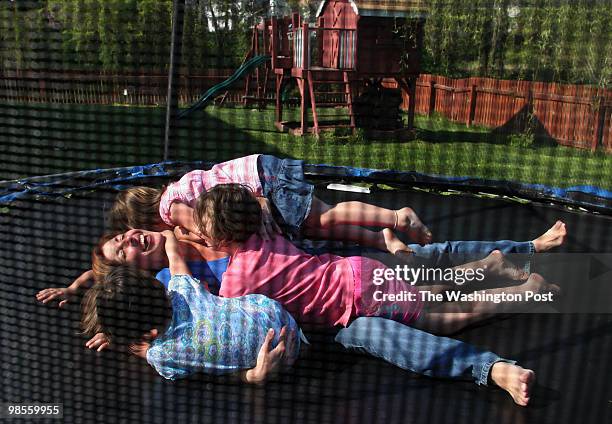 Christina Zukor plays with her four adopted Russian children, Natasha, 5; Nadia, 6; Elya, 7 and Anatoly, 9 on a trampoline in their yard. The Zukors...