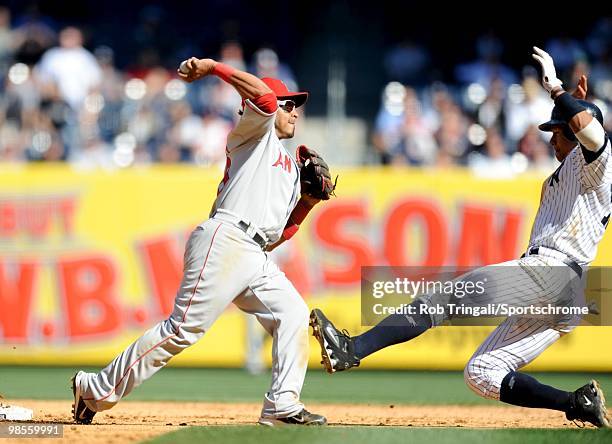 Maicer Izturis of the Los Angeles Angels of Anaheim attempts to complete a double play as Alex Rodriguez of the New York Yankees slides at Yankee...