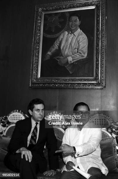 Sitting beneath a portrait of former Filipino President Ferdinand Marcos, US Congressman Stephen Solarz, and Filipino government investigator Jovita...