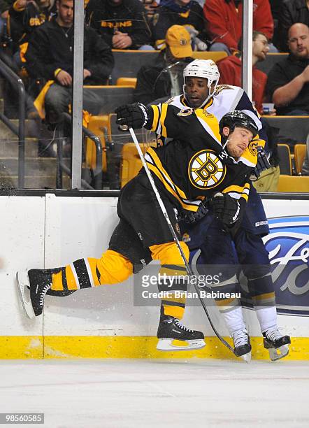 Andrew Ference of the Boston Bruins checks Michael Grier of the Buffalo Sabers in Game Three of the Eastern Conference Quarterfinals during the 2010...