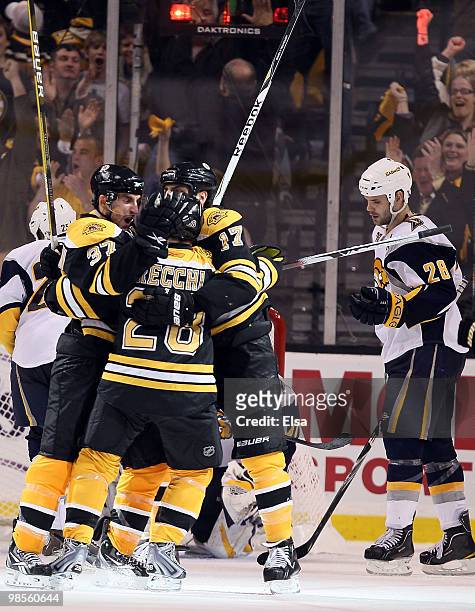 Patrice Bergeron of the Boston Bruins is congratulated by teammates Mark Recchi and Milan Lucic after Bergeron scored the game winner in the third...