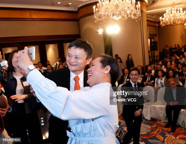 Alibaba Group co-founder and executive chairman Jack Ma poses with a Filipino guest during a news conference on June 25, 2018 in Hong Kong, China....