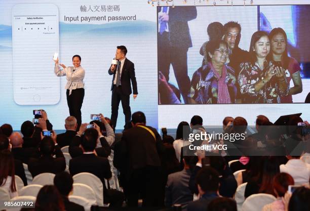 Filipino guest demonstrates the cross-border remittance service between Hong Kong and the Philippines during a news conference on June 25, 2018 in...