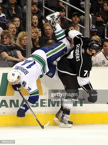 Alexandre Burrows of the Vancouver Canucks is checked by Rob Scuderi of the Los Angeles Kings during the first period in game three of the Western...