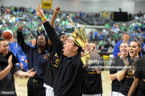 Freedom's Head Coach Jason Eldredge holding the State Championship Trophy and signals to the crowd it's the second year in a row for his team on...