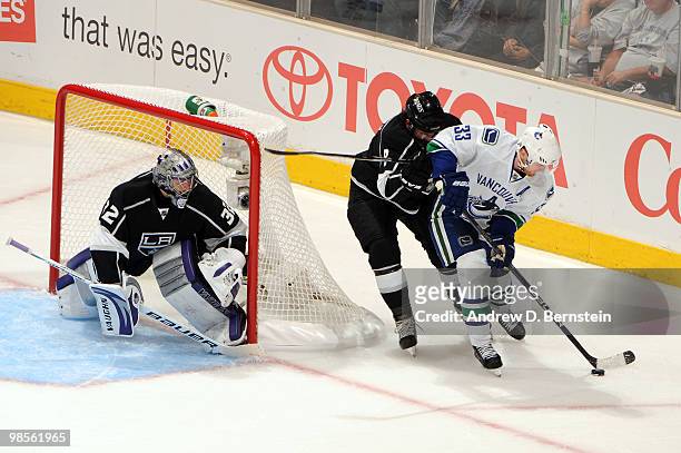 Henrik Sedin of the Vancouver Canucks skates with the puck against Drew Doughty and Jonathan Quick of the Los Angeles Kings in Game Three of the...