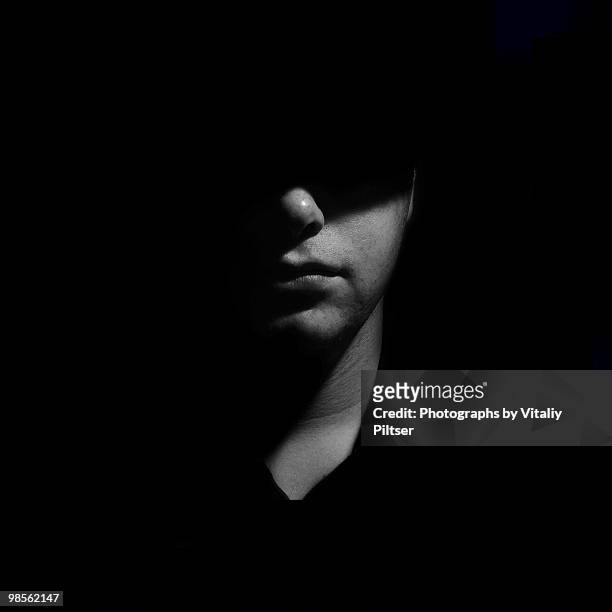 square crop portrait of half lit male face. - obscured face stock pictures, royalty-free photos & images