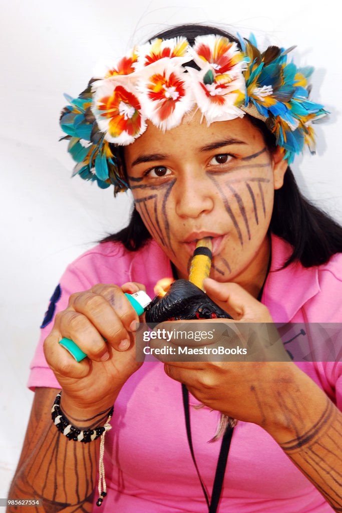 Young native Amazonian woman smoking on a Pipe.