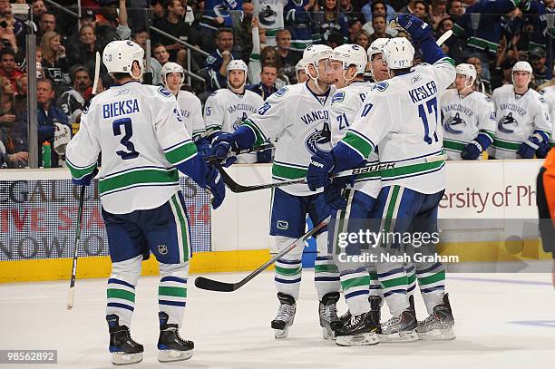 Kevin Bieksa, Aaron Rome, Mason Raymond and Ryan Kesler of the Vancouver Canucks celebrate after a goal against the Los Angeles Kings in Game Three...