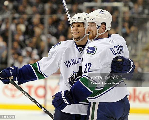 Daniel Sedin of the Vancouver Canucks celebrates his goal with Kevin Bieksa to trail 4-3 to the Los Angeles Kings during the third period in game...