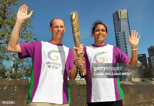 Legendary Australian Olympic and Commonwealth Games runners Steve Moneghetti and Cathy Freeman hold the baton aloft as the Queen's Baton Relay makes...