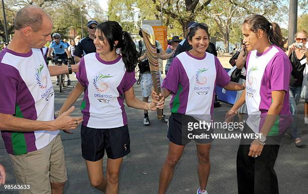 Legendary Australian Olympic and Commonwealth Games runners Steve Moneghetti and Cathy Freeman receive the baton from local Indian resident Chandni...