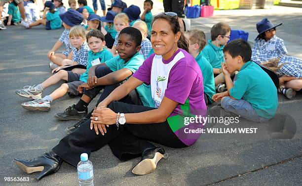 Legendary Australian Olympic and Commonwealth Games runner Cathy Freeman sits with schoolchildren while waiting for the baton as the Queen's Baton...