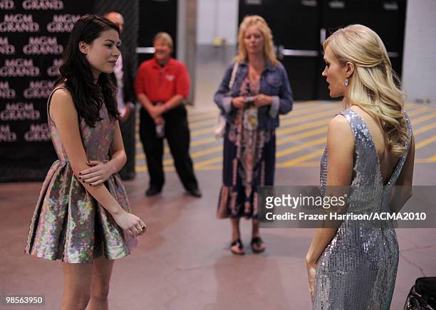 Actress Miranda Cosgrove and musician Carrie Underwood speak backstage during Brooks & Dunn's The Last Rodeo Show at the MGM Grand Garden Arena on...