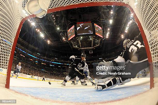 Jonathan Quick of the Los Angeles Kings reaches for the puck as his teammate Rob Scuderi battles for position against Henrik Sedin of the Vancouver...