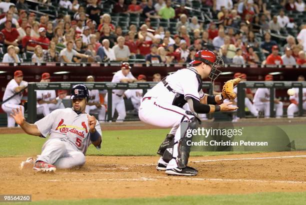 Albert Pujols of the St. Louis Cardinals slides in to score a run past catcher Chris Snyder of the Arizona Diamondbacks during the ninth inning of...