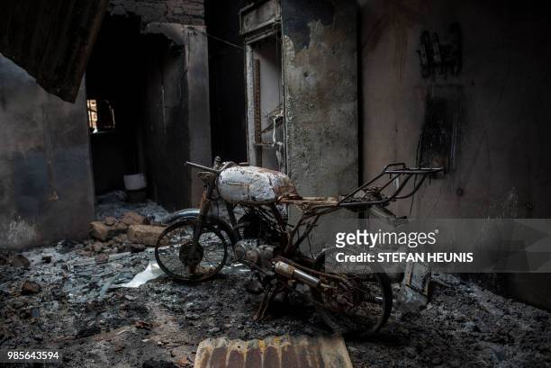 The frame of a burnt out motorcycle is seen in a house burned down by Fulani herdsman in the Ganaropp village in the Barikin Ladi area near Jos on...