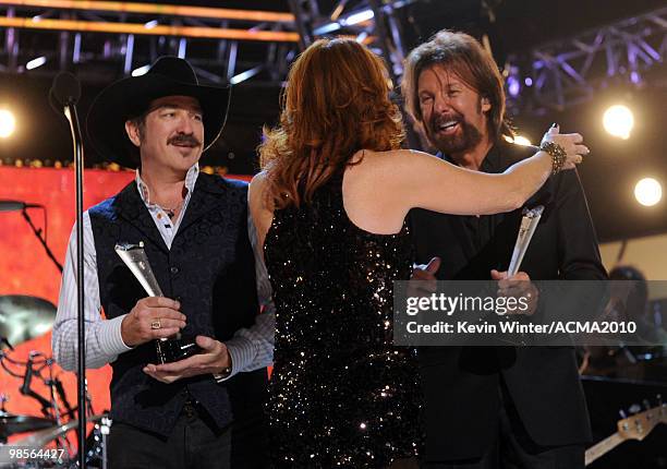 Musician Reba McEntire presents the ACM Milestone Award to Kix Brooks and Ronnie Dunn of the band Brooks & Dunn onstage during Brooks & Dunn's The...