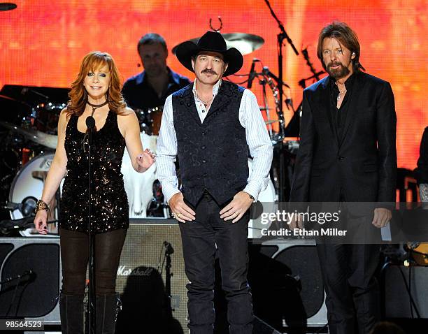 Musician Reba McEntire presents the ACM Milestone Award to musicians Kix Brooks and Ronnie Dunn of Brooks & Dunnn onstage during Brooks & Dunn's The...